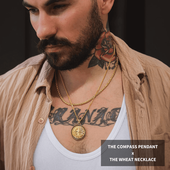 Man wearing gold compass pendant and wheat necklace layered over a white tank top and beige shirt, showcasing Build Your Own Bundle - Gold bold by design jewelry statement pieces.