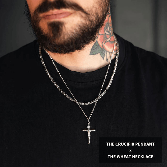 Man wearing layered silver chains featuring a crucifix pendant and a textured wheat necklace, showcasing the Build Your Own Bundle - Silver jewelry with bold, statement design.