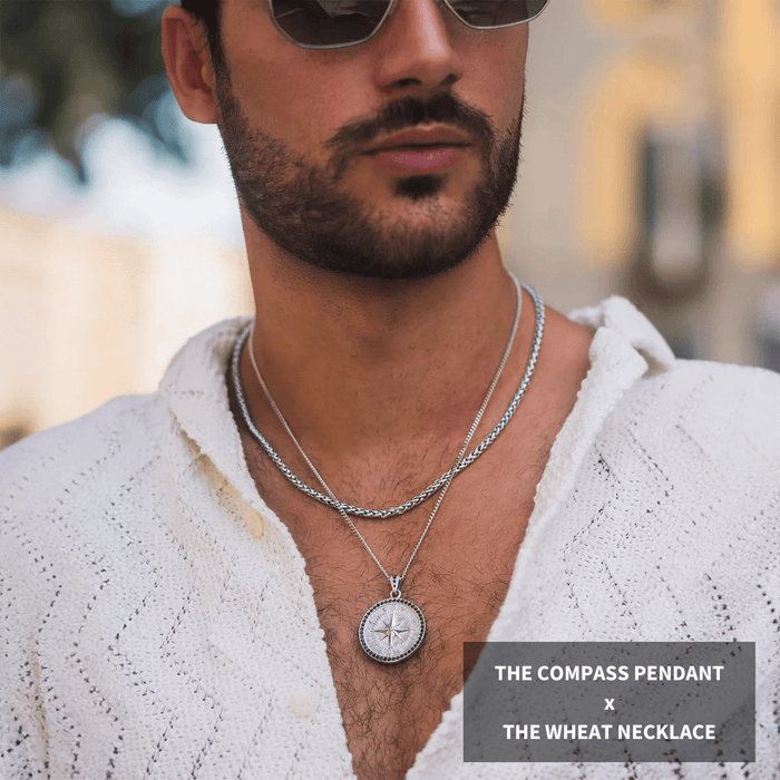 Man wearing Build Your Own Bundle - Silver, featuring a silver compass pendant with ice-set bezel and a matching silver wheat chain necklace, styled with a white textured shirt, showcasing bold men's jewelry by Ralph Christian.