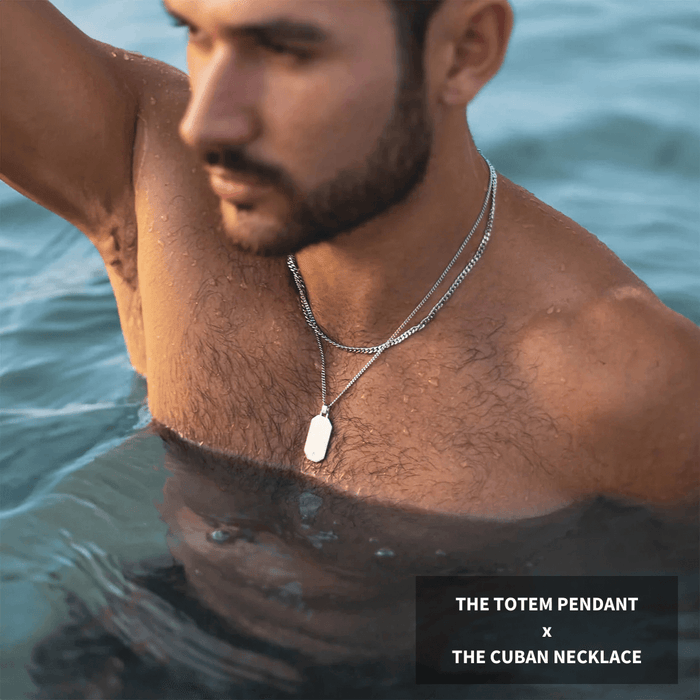 A man wearing the "Build Your Own Bundle - Silver," featuring a bold silver totem pendant and Cuban necklace, styled for men's jewelry with a sleek, modern look in water.