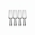 Set of four clear glass flutes on a white background
