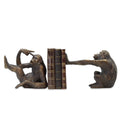 Bronze monkey bookends holding a book on a white background