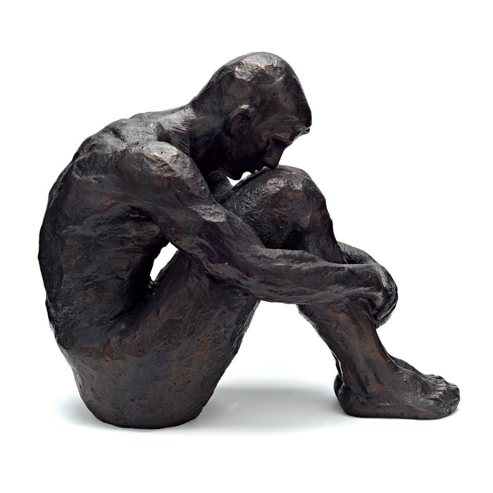 Bronze sculpture of a seated figure with hands clasped, on a white background