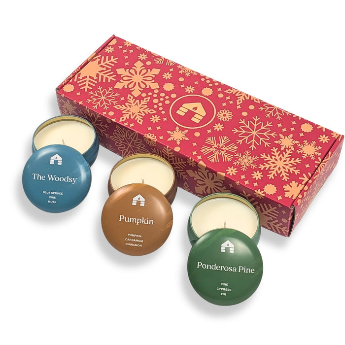 Scented candle gift set featuring three 8oz Aromática candle tins: Pumpkin, The Woodsy, and Ponderosa Pine, in festive packaging. great candles for xmas