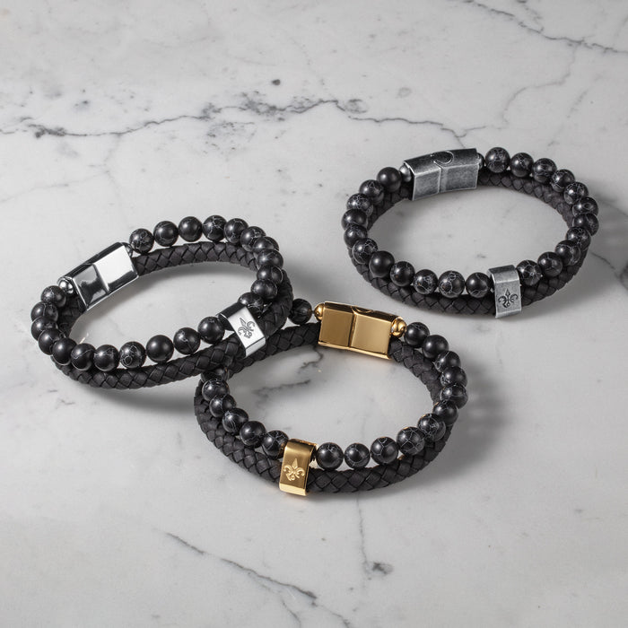 Three men's luxury bracelets featuring black beaded and braided leather designs with silver and gold clasps, showcasing The Ambassador Bracelet - Silver style.