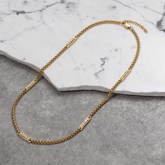 The Atlas Ice Necklace featuring a bold gold chain with rectangular links accented by sparkling cubic zirconia stones, designed for men's luxury jewelry, bold by design.