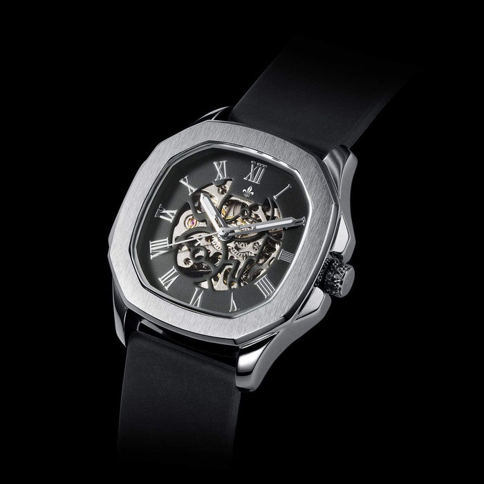 The Avalon - Silver men's luxury watch featuring a brushed silver octagonal case, black dial with visible skeleton movement, Roman numeral markers, and a black strap, bold by design.
