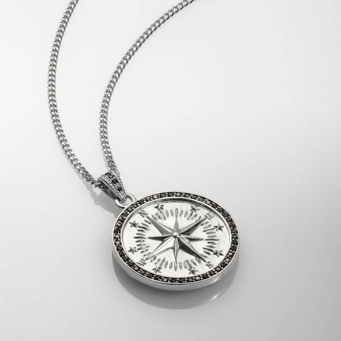 Close-up of The Compass Essentials Bundle - Silver pendant featuring a polished silver compass design with black cubic zirconia accents on a sleek chain, bold by design.