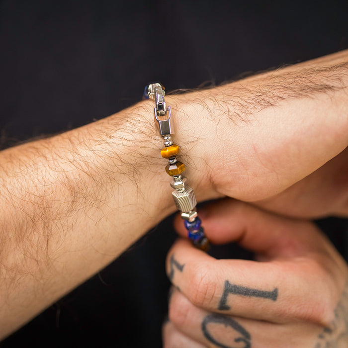 The Damascus Voyage Bracelet displayed on a wrist, featuring a mix of metallic beads in silver and bronze tones with a distinctive bold design, embodying statement jewelry style.