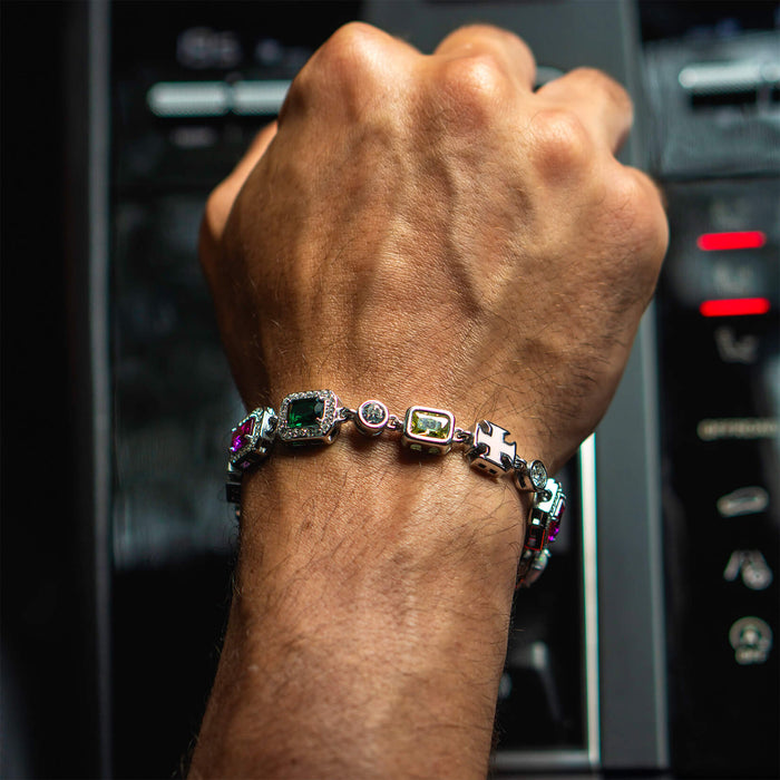 A close-up lifestyle shot of a wrist wearing The Gemstone Bracelet featuring multicolored cubic zirconia stones set in a sleek silver-tone design, highlighting bold luxury jewelry.