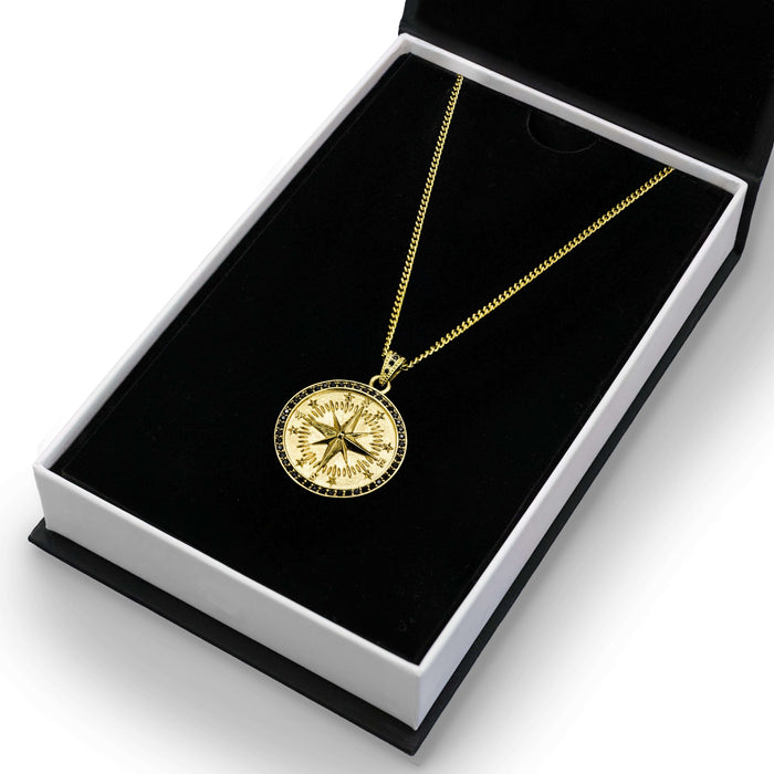 The Gold Compass Pendant - Essentials Collection, a bold men's jewelry piece in polished gold with a detailed compass design, presented in a black and white gift box.