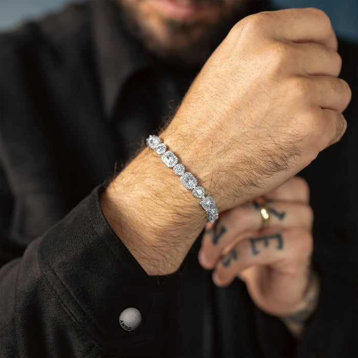The Iced Versailles Bracelet worn on a male wrist features a bold design with large, sparkling cubic zirconia stones set in a silver-tone metal, creating a standout luxury statement piece.