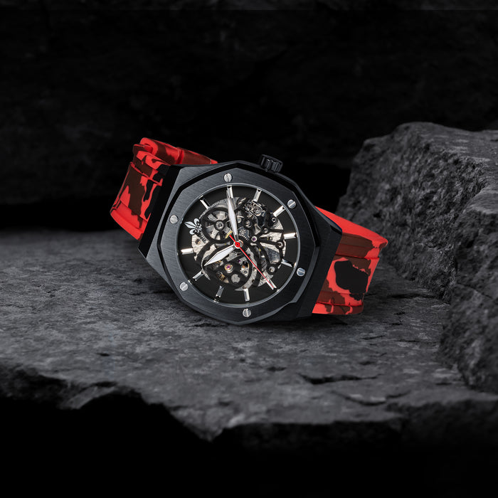 The Maverick STEEL - Camo Red men's luxury watch with a black steel case, skeleton dial revealing intricate chronograph subdials, red camo patterned silicone strap, and bold design accents.