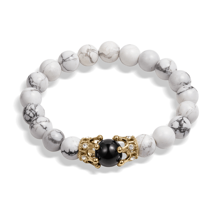 The Royal Howlite Bracelet featuring polished white howlite beads with gray veining, accented by a gold-tone centerpiece clasp holding a black bead, men's luxury jewelry.