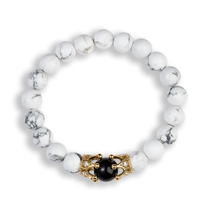 The Royal Howlite Bracelet features round white howlite beads with delicate gray veining, accented by a gold-tone crown centerpiece adorned with black and clear cubic zirconia stones, designed for men. Bold by Design.