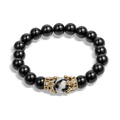 The Royal Obsidian Bracelet featuring polished black beads with a central marbled bead flanked by detailed gold-tone crown accents, designed for men.