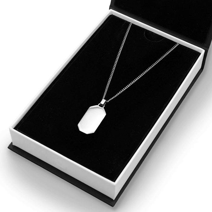 The Silver Totem Pendant - Essentials Collection featuring a men's sleek silver pendant necklace with a polished, geometric design, presented in a black and white luxury gift box.