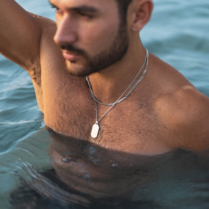 Man wearing The Silver Totem Pendant - Essentials Collection in silver on double chain necklace, partially submerged in water for a bold men's jewelry lifestyle shot.